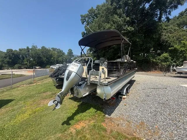 Slide: The Image of A 2017 Starcraft MX 23 C pontoon boat on a trailer in a gravel lot. - 3