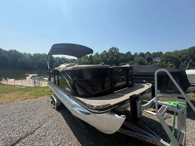 Slide: The Image of A 2017 Starcraft MX 23 C pontoon boat on a trailer near a lakeside. - 4