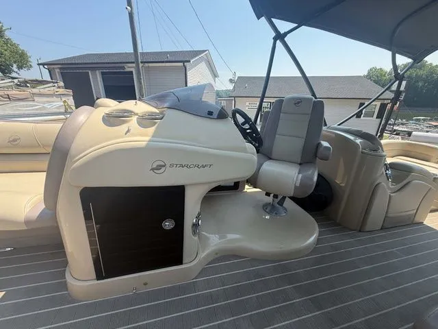Slide: The Image of The image shows the cockpit of a 2017 Starcraft MX 23 C boat with beige interior. - 16
