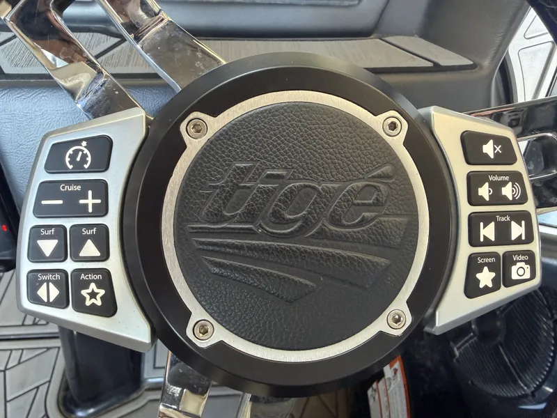 Slide: The Image of Steering wheel of a Tigé 23ZX boat with control buttons. - 32
