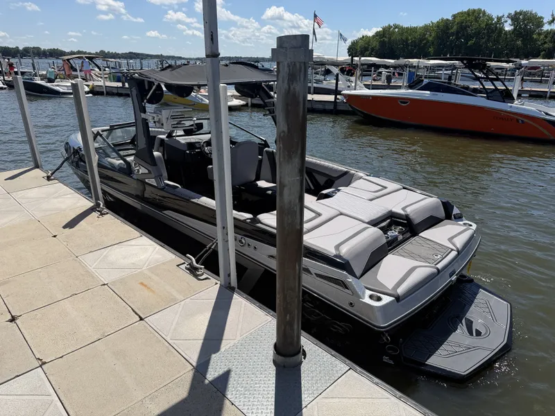 The Image of A 2021 Tigé 23ZX docked. It features a sleek design and is surrounded by other boats. - 1