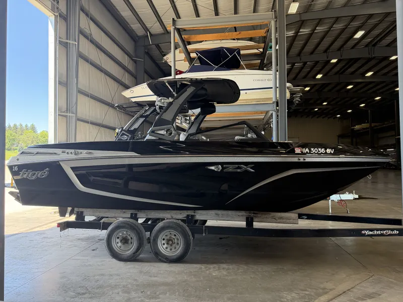 Slide: The Image of A black 2021 Tigé 23ZX boat sits on a trailer in a warehouse. - 5