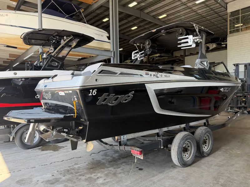 Slide: The Image of A black 2021 Tigé 23ZX boat on a trailer in a warehouse setting. - 6