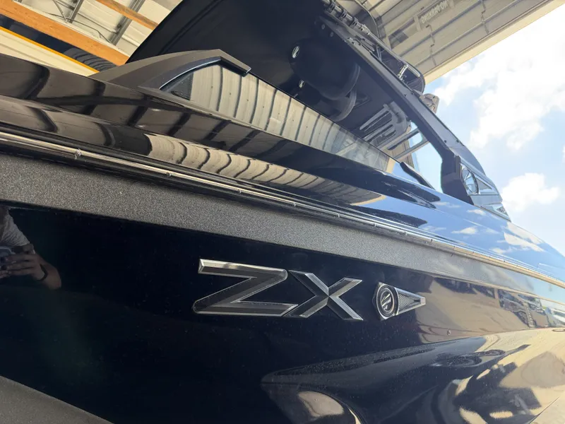 Slide: The Image of Close-up of a black 2021 Tigé 23ZX boat in a warehouse. - 10