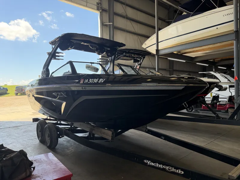 Slide: The Image of A black 2021 Tigé 23ZX boat is on a trailer inside a warehouse. - 4