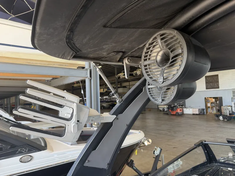 Slide: The Image of A 2021 Tigé 23ZX with speakers and a wakeboard rack under a black canopy. - 44