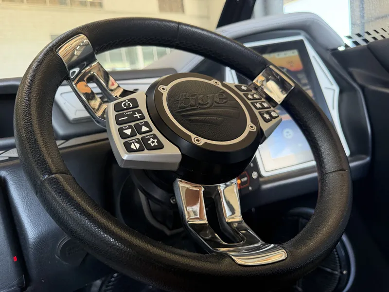 Slide: The Image of The image shows the steering wheel of a 2021 Tigé 23ZX boat with integrated controls. - 31