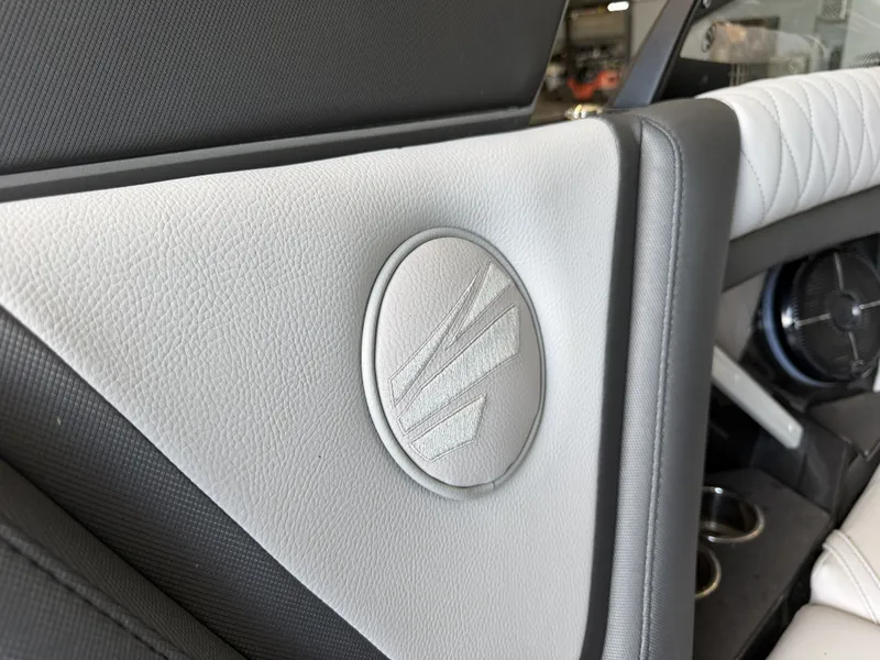 Slide: The Image of Close-up of a boat interior with gray and white upholstery and a round logo. - 49