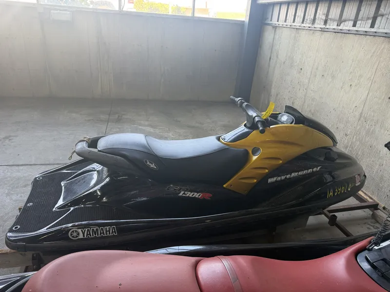 Slide: The Image of A 2006 Yamaha GP1300R jet ski in a garage, painted black and yellow. - 7