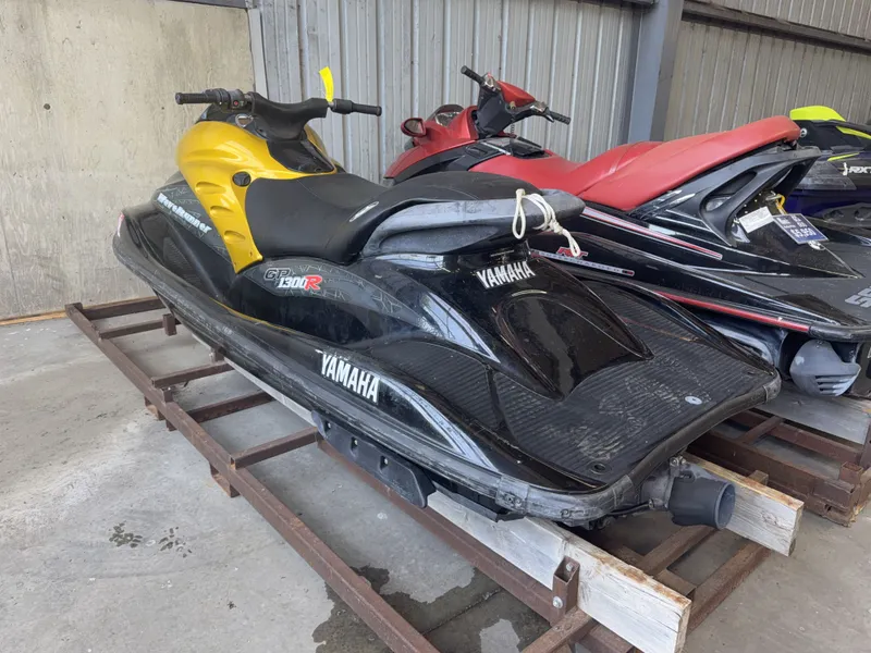 Slide: The Image of A 2006 Yamaha GP1300R jet ski in black and yellow, stored on a metal rack. - 5