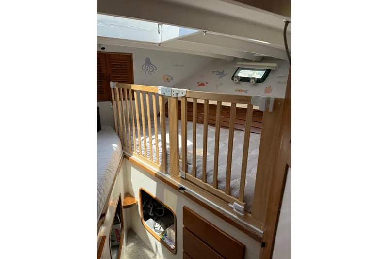 Slide: The Image of 1978 Roughwater 41 twin cabin interior with wooden railing and nautical-themed decor. - 17
