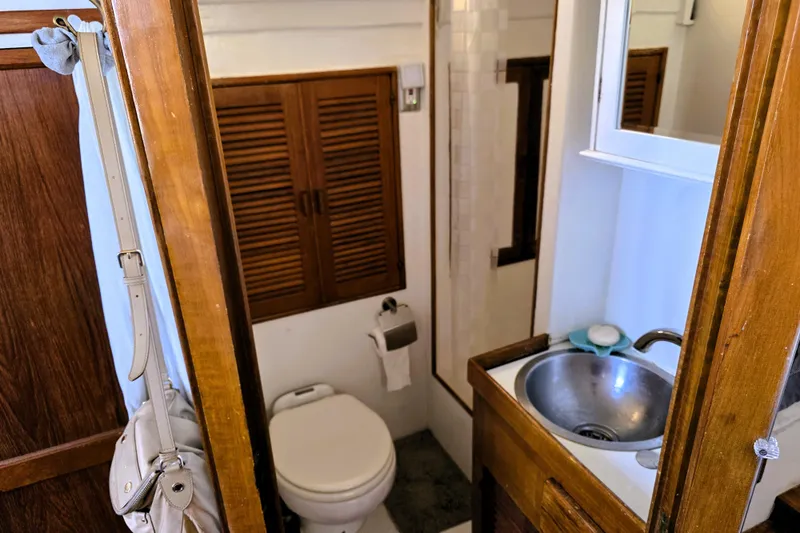 Slide: The Image of 1978 Roughwater 41 twin cabin bathroom with wooden accents and compact sink. - 8