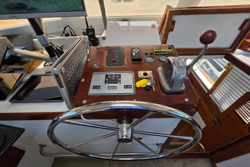 Slide: The Image of 1978 Roughwater 41 twin cabin helm with steering wheel, controls, and navigation equipment. - 28