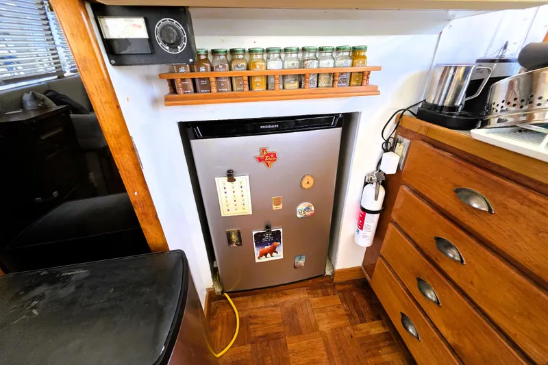 Slide: The Image of 1978 Roughwater 41 Twin Cabin kitchen with fridge, spice rack, and wooden drawers. - 32