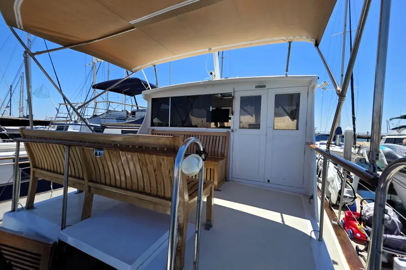 Slide: The Image of 1978 Roughwater 41 Twin Cabin yacht with wooden seating and canopy, docked at marina. - 21