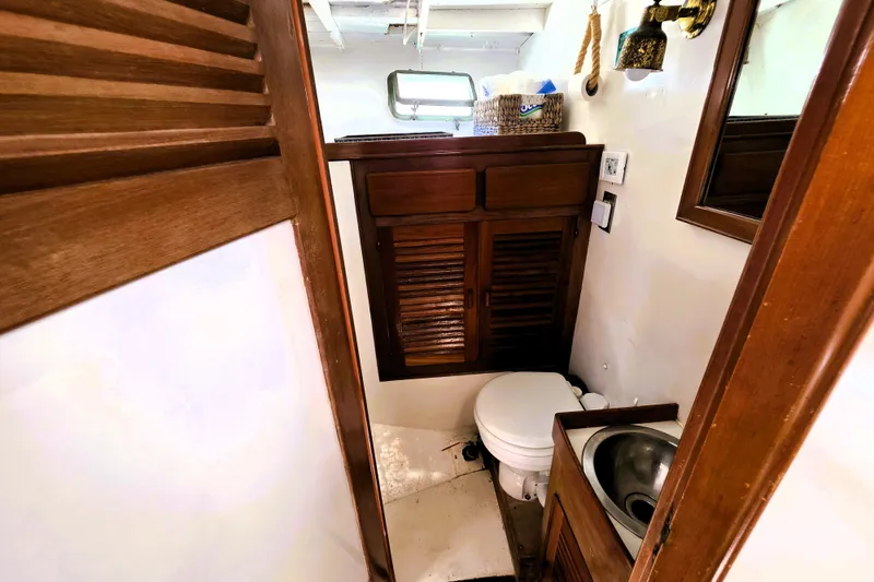 Slide: The Image of 1978 Roughwater 41 twin cabin bathroom with wooden cabinets, toilet, and sink. - 5