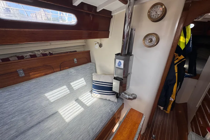 Slide: The Image of Interior of a 1955 Henry R Hinckley Owens Cutter, featuring a cozy seating area and nautical decor. - 8