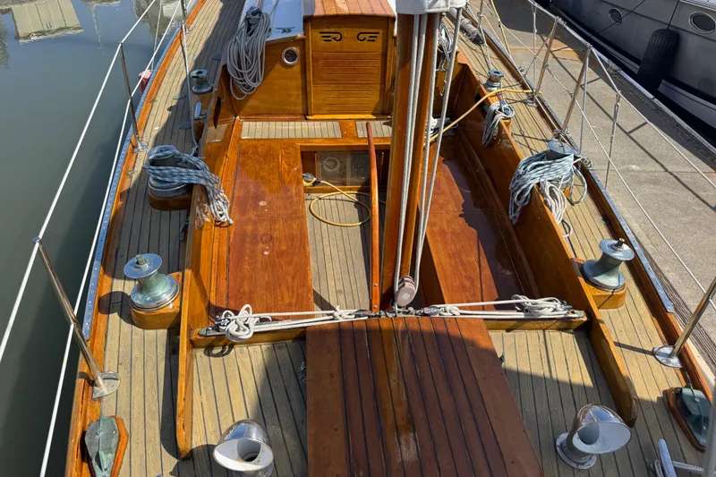 Slide: The Image of 1955 Henry R Hinckley Owens Cutter sailboat deck with polished wood and nautical ropes. - 17