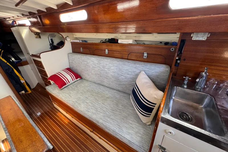 Slide: The Image of 1955 Henry R Hinckley Owens Cutter interior with wooden finish, cozy seating, and compact sink. - 9