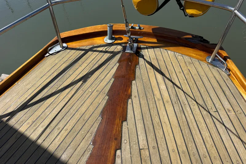 Slide: The Image of Wooden deck of a 1955 Henry R Hinckley Owens Cutter sailboat, featuring polished railings. - 21