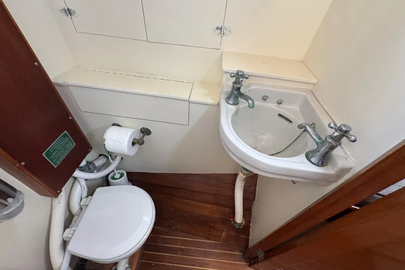 Slide: The Image of 1955 Henry R Hinckley Owens Cutter bathroom with vintage sink and toilet setup. - 14