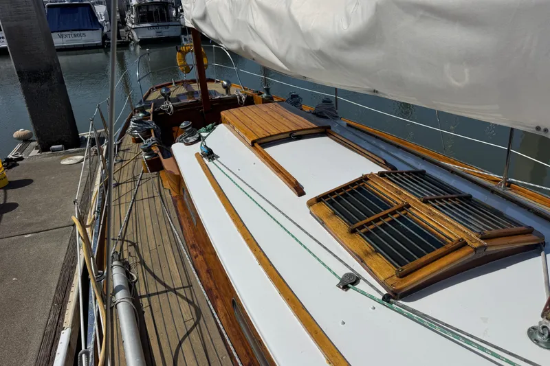 Slide: The Image of 1955 Henry R Hinckley Owens Cutter sailboat docked, showcasing wooden deck and classic design. - 18