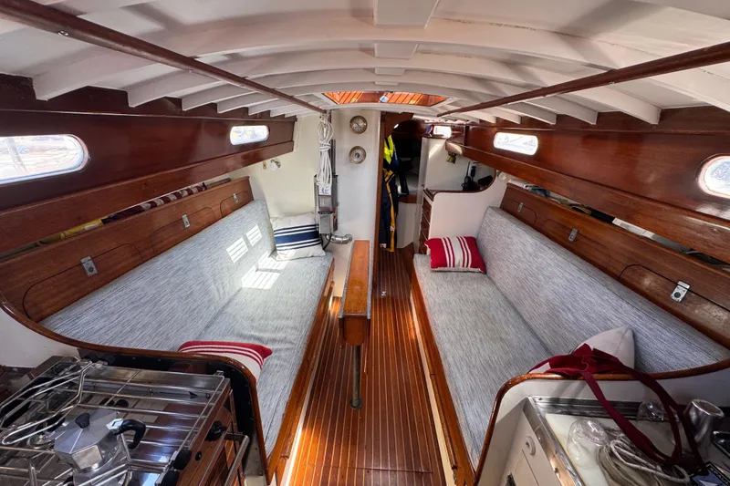 Slide: The Image of Interior of a 1955 Henry R Hinckley Owens Cutter sailboat with wooden accents and cozy seating. - 6