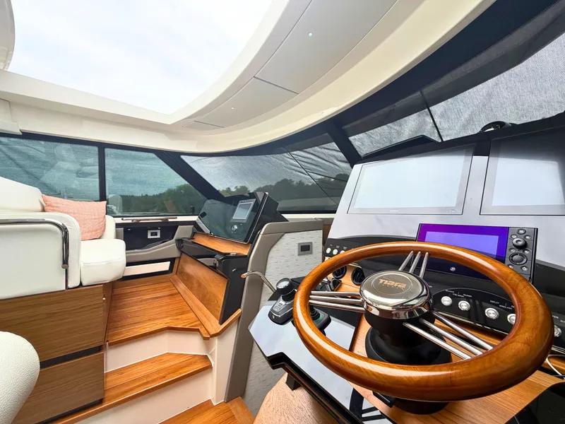 Slide: The Image of Interior of the 2025 Tiara Yachts 48 LE with modern helm and wood accents. - 8