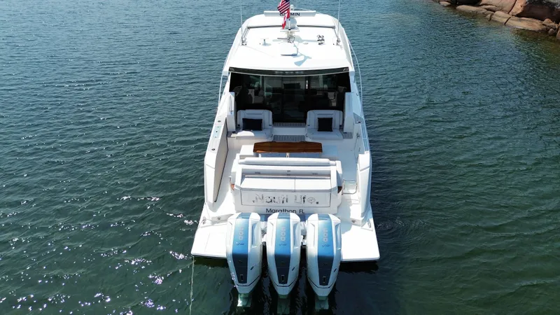 Slide: The Image of 2025 Tiara Yachts 48 LE on calm water with three outboard engines. - 5