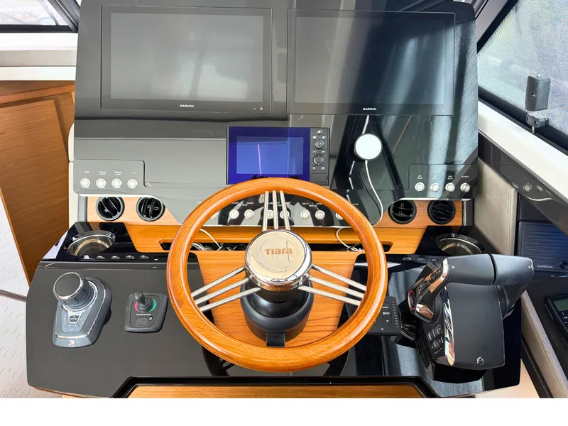 Slide: The Image of The cockpit of the 2025 Tiara Yachts 48 LE features a sleek steering wheel and modern instruments. - 13
