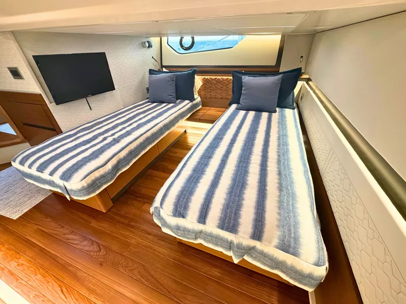 Slide: The Image of Two single beds with striped bedding in an elegant cabin with wooden flooring. - 28