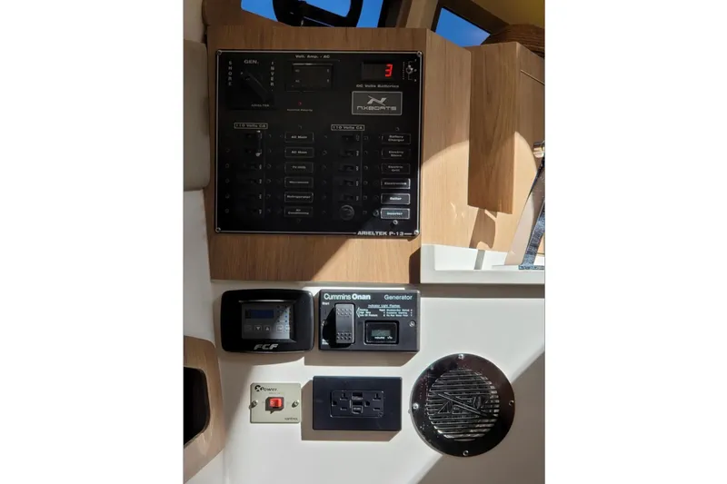 Slide: The Image of Control panel of 2023 NX Boats 340 Sport Coupe with generator and electrical switches. - 30