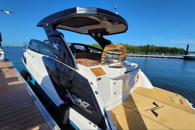 Slide: The Image of 2023 NX Boats 340 Sport Coupe docked, showcasing sleek design and modern features. - 4