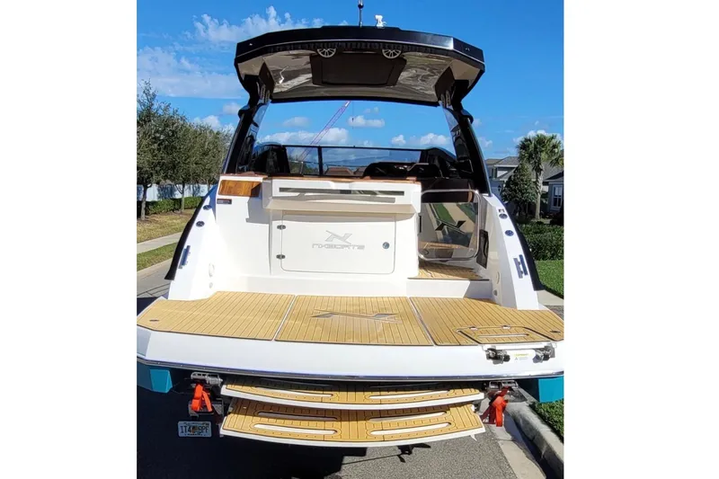 Slide: The Image of Rear view of an NX Boats 340 Sport Coupe with wooden deck and modern design. - 8
