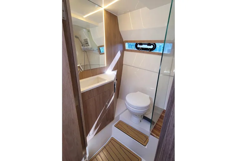 Slide: The Image of Modern bathroom interior of 2023 NX Boats 340 Sport Coupe, featuring sleek design and wood accents. - 28