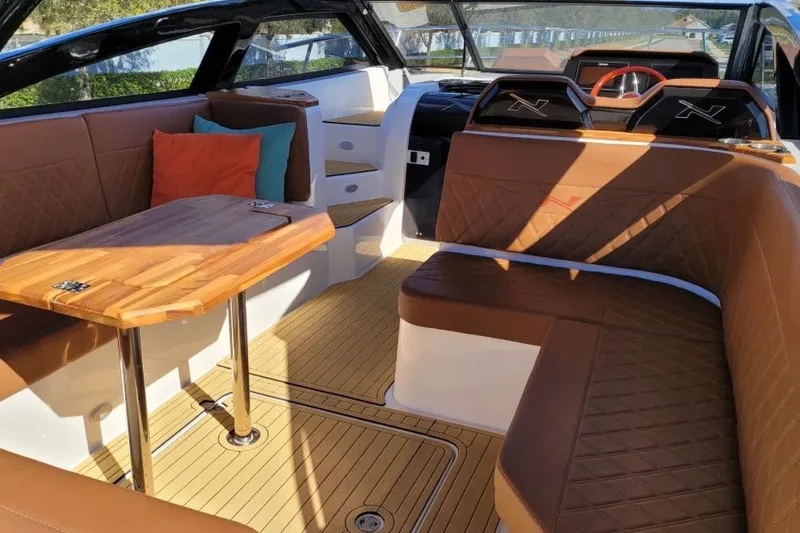 Slide: The Image of Luxurious interior of 2023 NX Boats 340 Sport Coupe with elegant seating and wooden table. - 14