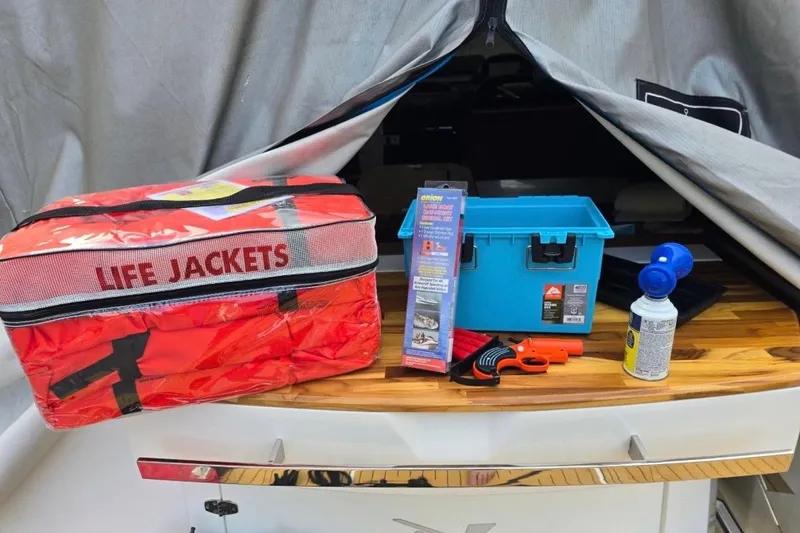 Slide: The Image of Safety equipment on NX Boats 340 Sport Coupe, including life jackets and emergency gear, 2023 model. - 32