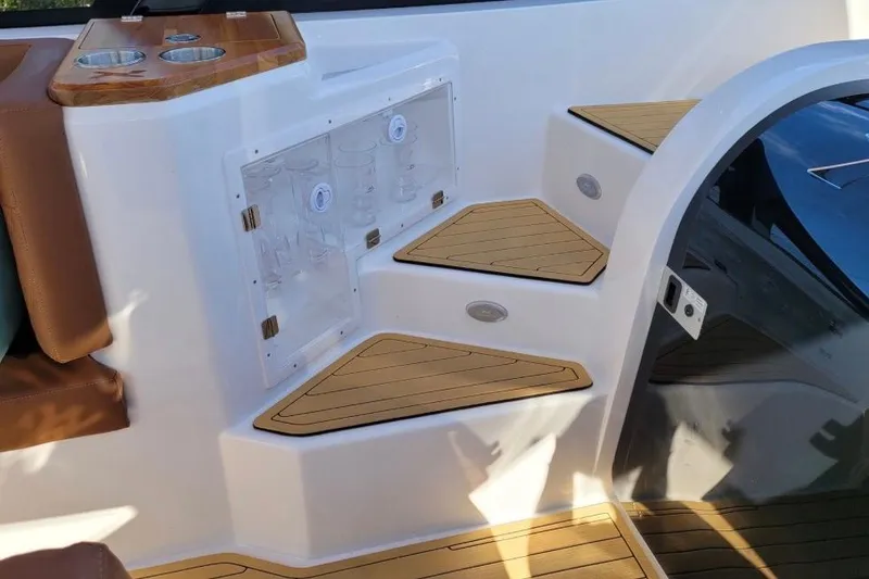 Slide: The Image of Interior of 2023 NX Boats 340 Sport Coupe featuring wooden steps and seating area. - 16