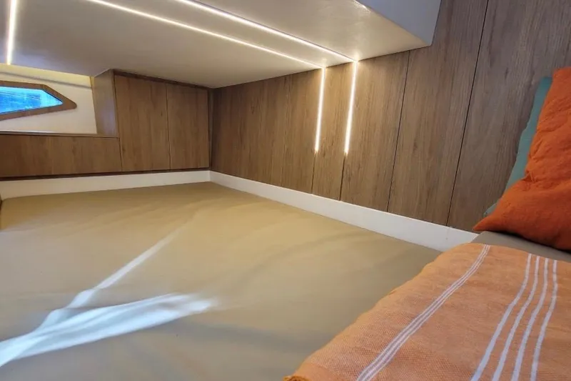 Slide: The Image of Interior cabin of 2023 NX Boats 340 Sport Coupe with modern wood paneling and ambient lighting. - 24