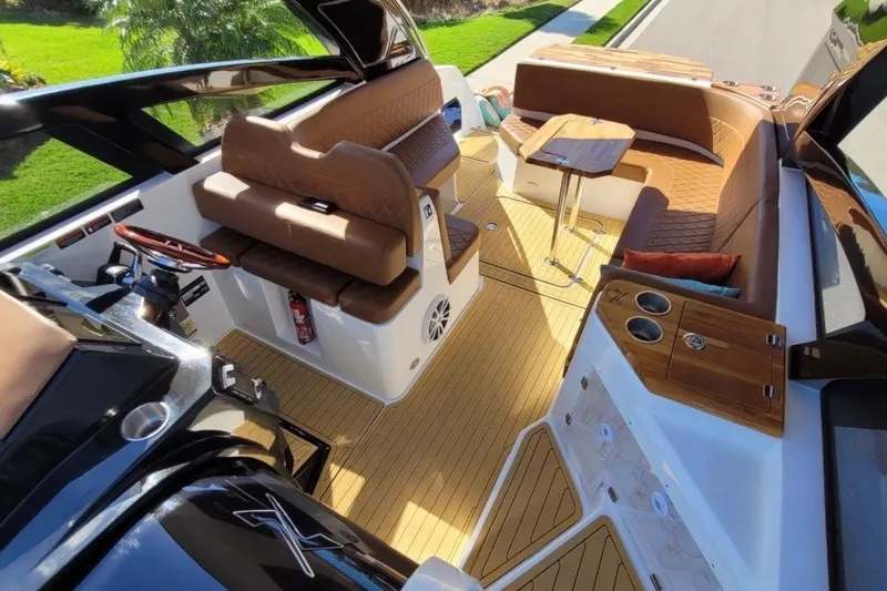Slide: The Image of 2023 NX Boats 340 Sport Coupe interior with luxurious seating and wooden accents. - 15