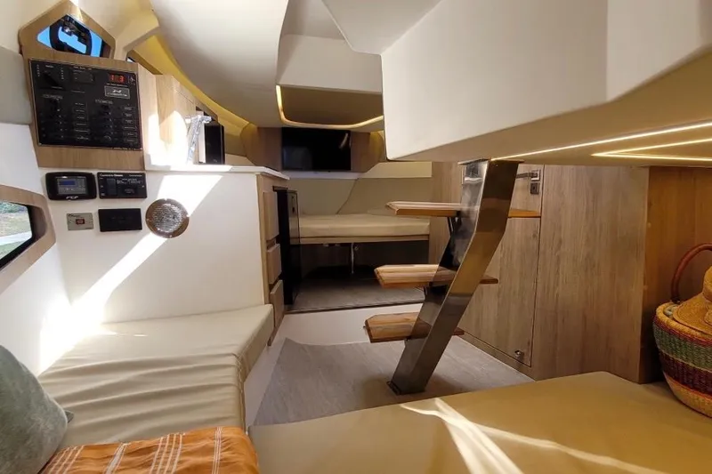 Slide: The Image of Interior of 2023 NX Boats 340 Sport Coupe, featuring modern design and cozy seating area. - 27