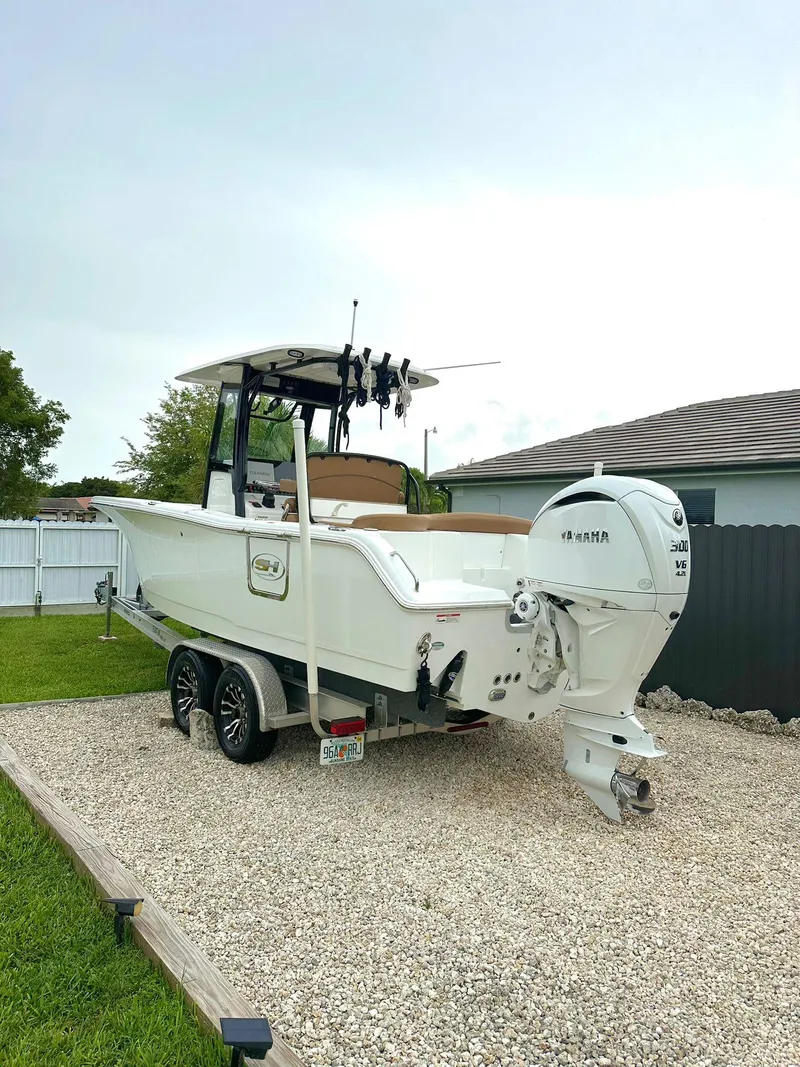 Slide: The Image of 2022 Sea Hunt Ultra 255 SE boat on trailer in residential yard. - 5
