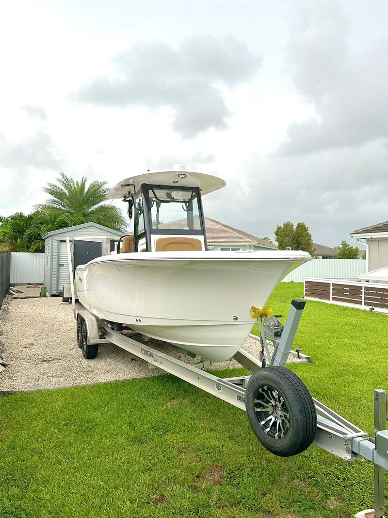 Slide: The Image of 2022 Sea Hunt Ultra 255 SE boat on trailer in residential yard. - 32