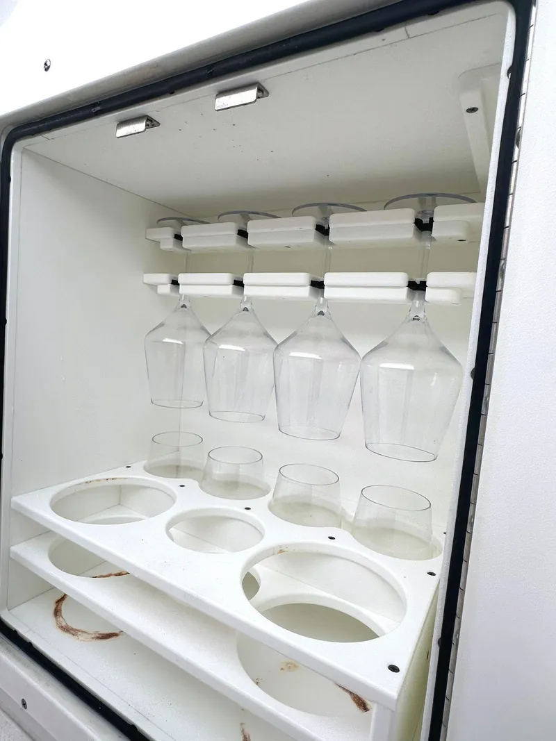 Slide: The Image of Glass holder in a 2022 Sea Hunt Ultra 255 SE boat, featuring wine and tumbler slots. - 20