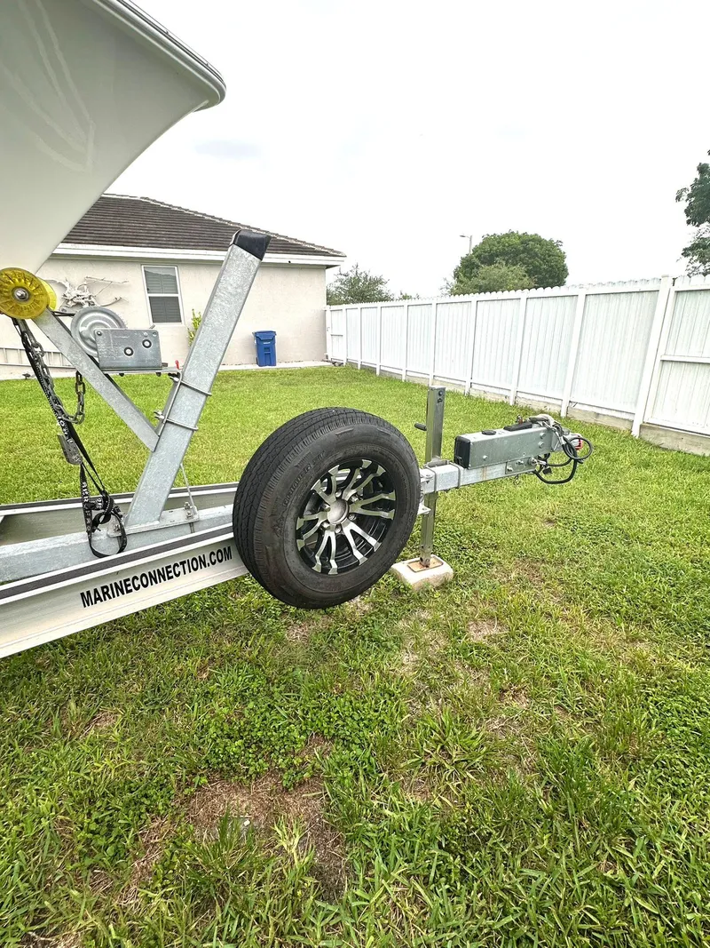 Slide: The Image of Trailer for 2022 Sea Hunt Ultra 255 SE boat parked on grass. - 30