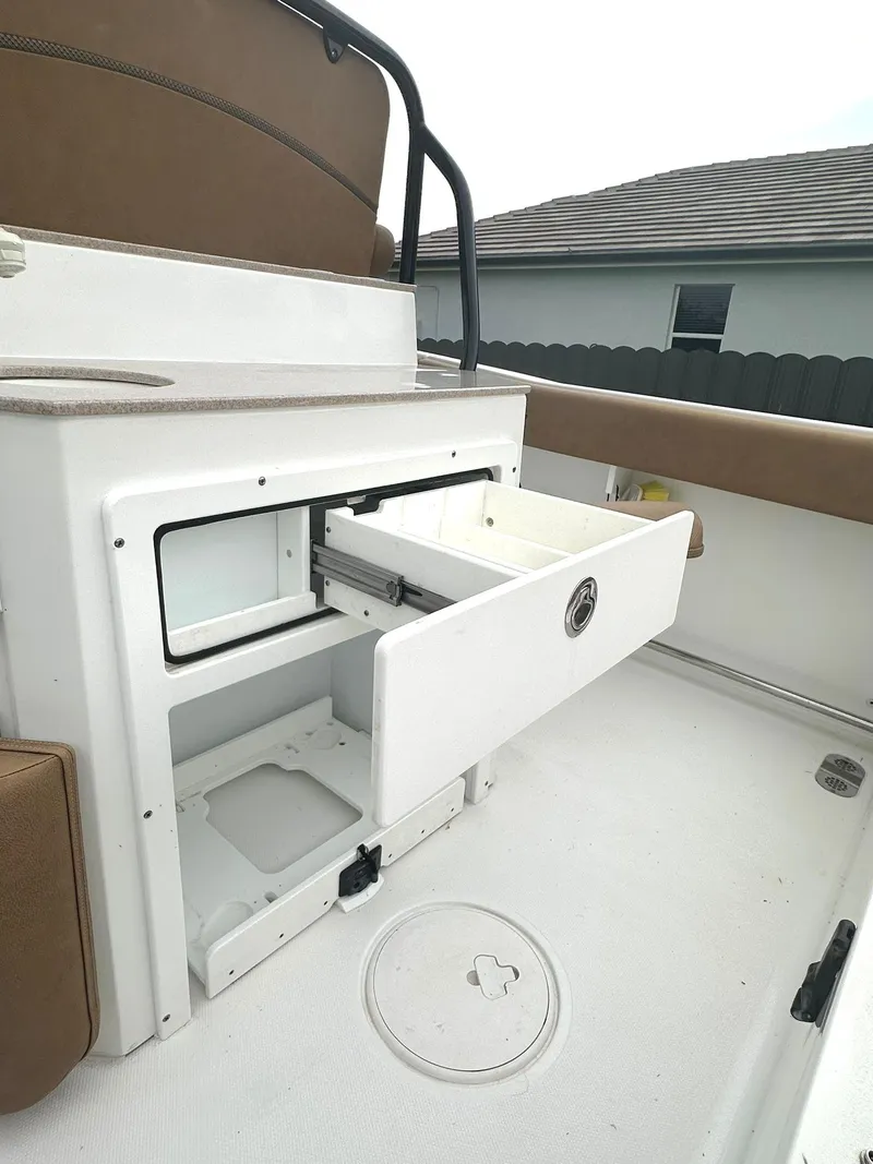Slide: The Image of 2022 Sea Hunt Ultra 255 SE boat interior with open storage drawer. - 13