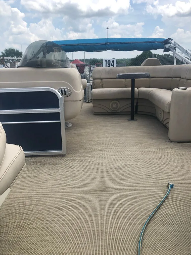 Slide: The Image of The image shows the deck of a Misty Harbor pontoon boat with beige seating and a table. - 6