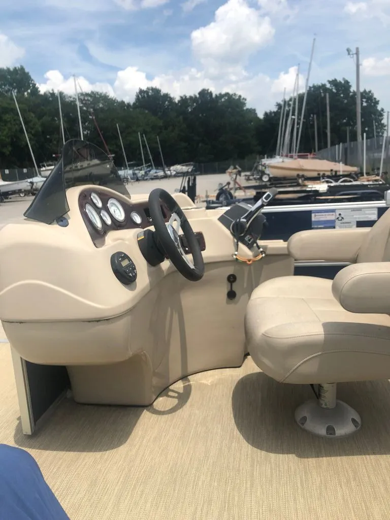 Slide: The Image of The image shows a boat's cockpit with a steering wheel and instruments. Boats are visible in the harbor background. - 4