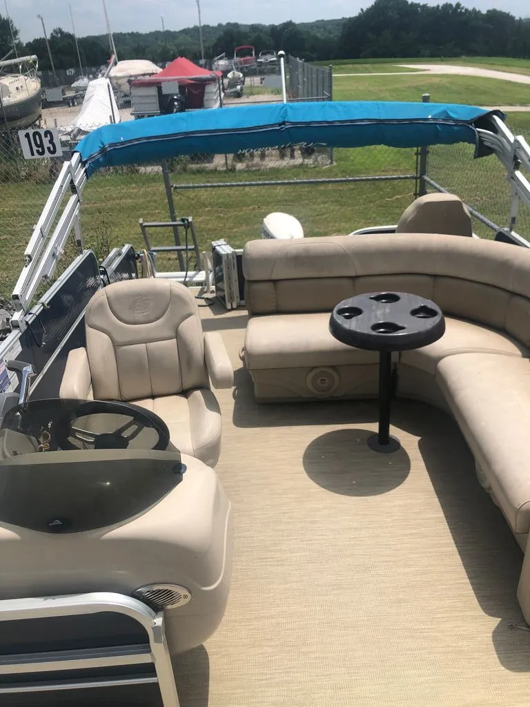Slide: The Image of The image shows the deck of a Misty Harbor pontoon boat with beige seating and a table. - 3