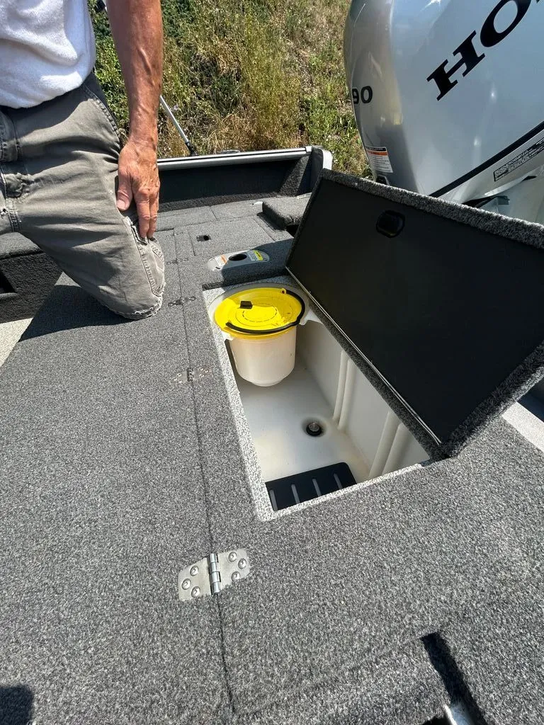 Slide: The Image of An open storage compartment on a boat with a yellow bucket inside. - 10